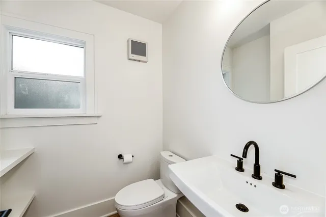 a bathroom with a sink mirror and toilet