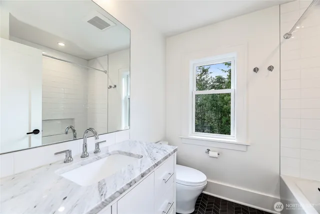 a bathroom with a granite countertop sink toilet and shower