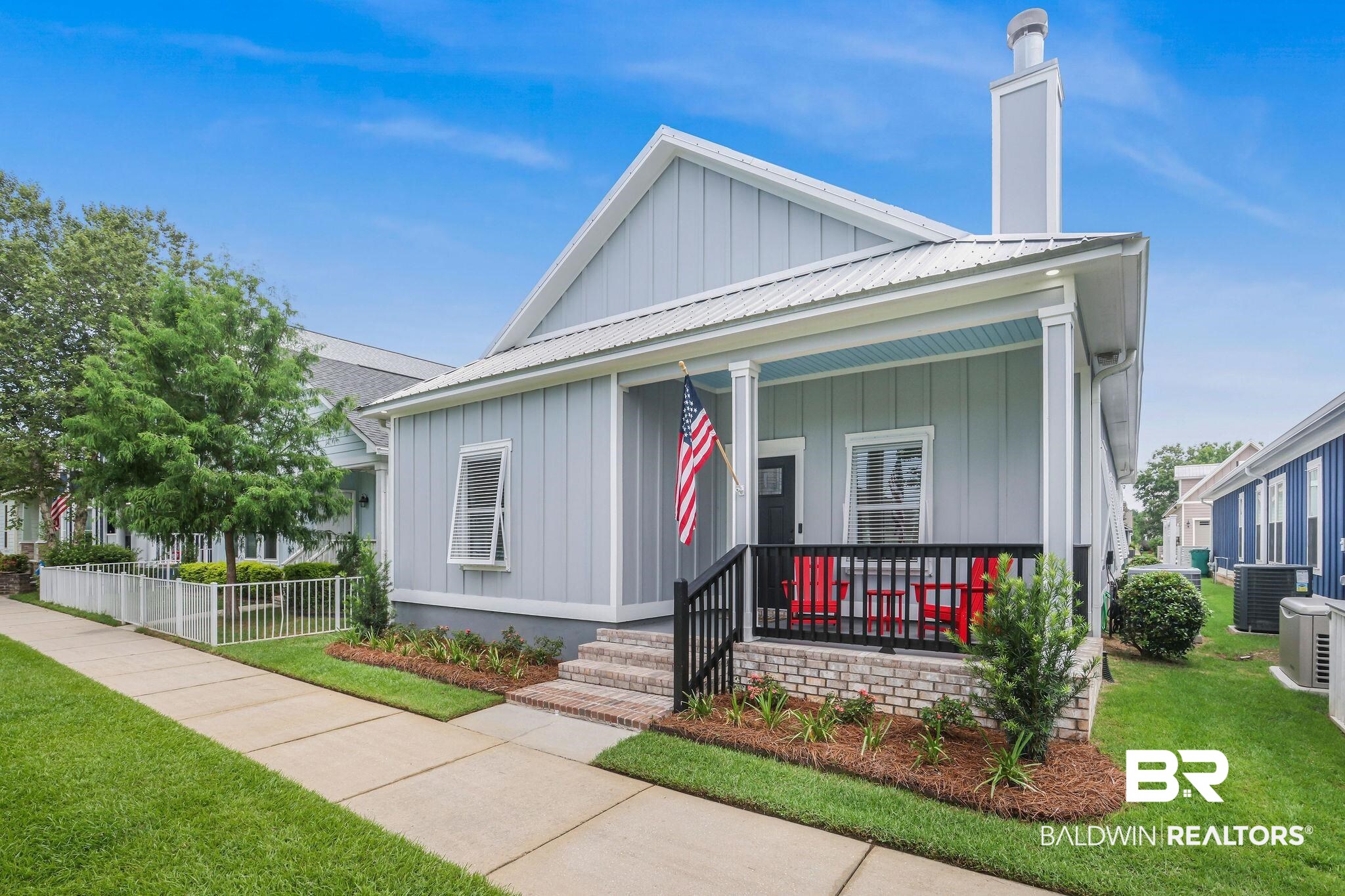 View of front of house featuring a porch, a metal roof, board and batten siding, and a chimney