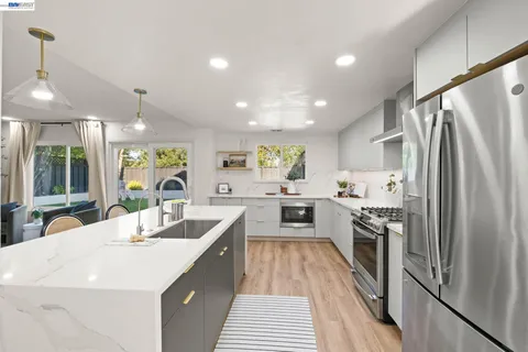 a kitchen with a sink stainless steel appliances and window