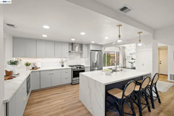 a kitchen with granite countertop a sink appliances cabinets wooden floor and dining table