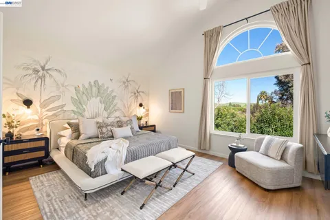 a bedroom with furniture and a large window