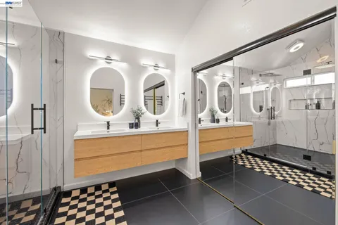a bathroom with a double vanity sink mirror and bathtub