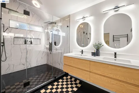 a bathroom with a double vanity sink mirror and shower