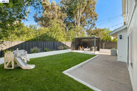 a view of a chair and table in the backyard