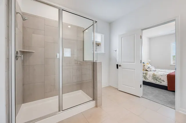 a spacious bedroom with a bed and a chandelier