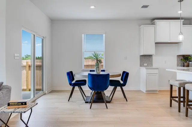 a kitchen with stainless steel appliances kitchen island granite countertop a table chairs sink and cabinets