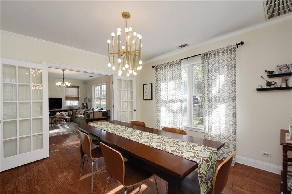 4412 Barrow Avenue, Unit A Austin, TX 78751 - Photo 7 of 28 Dining room featuring a chandelier, dark wood-style floors, ornamental molding, and plenty of natural light