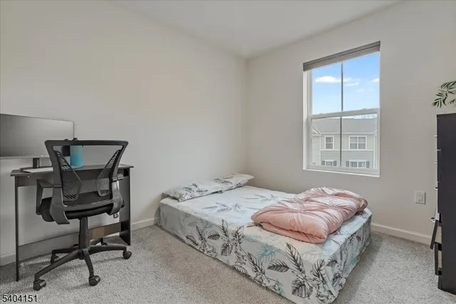 a bedroom with a bed a chair and a window