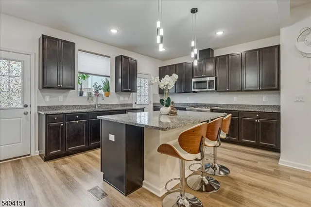 a kitchen with stainless steel appliances kitchen island granite countertop a sink and cabinets