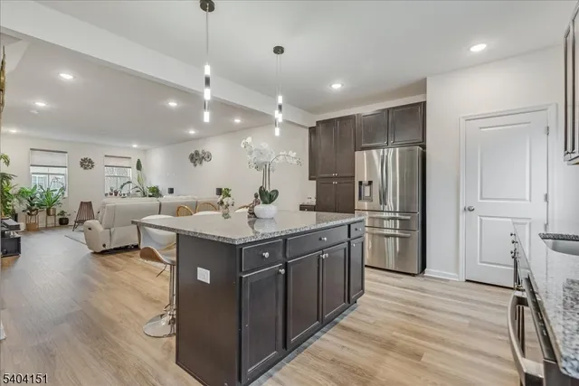 a kitchen with stainless steel appliances granite countertop a sink refrigerator and cabinets
