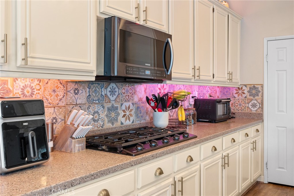 8553 Lodgepole Lane Riverside, CA 92508 - Photo 24 of 75 a kitchen with stainless steel appliances granite countertop a sink stove and microwave