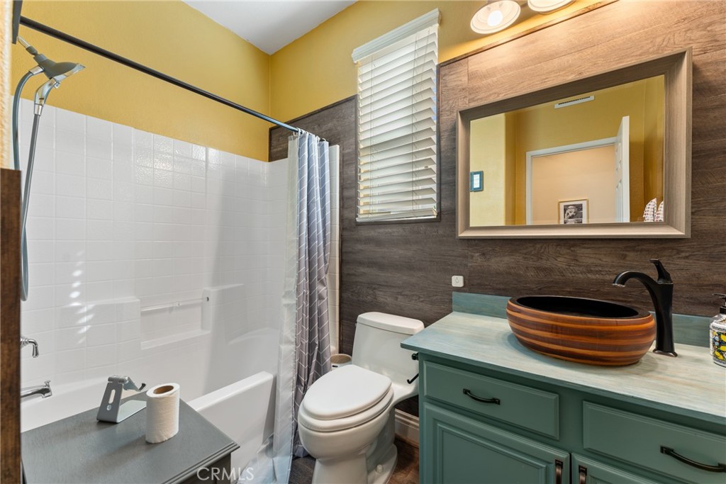 8553 Lodgepole Lane Riverside, CA 92508 - Photo 28 of 75 a bathroom with a sink a toilet and shower curtain