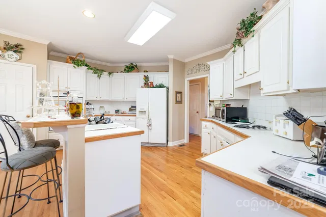 a kitchen with stainless steel appliances granite countertop a refrigerator sink and white cabinets