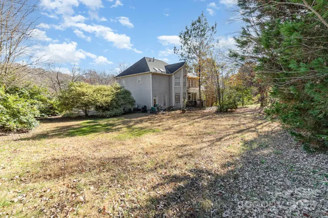 a view of a house with backyard and tree
