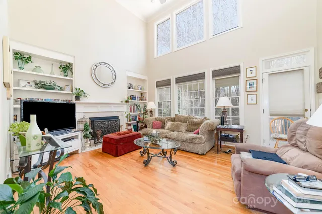 a living room with furniture a fireplace and a large window