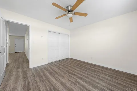 a view of an empty room with wooden floor