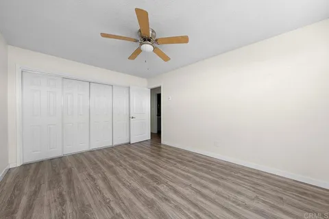 a view of a livingroom with a ceiling fan and wooden floor