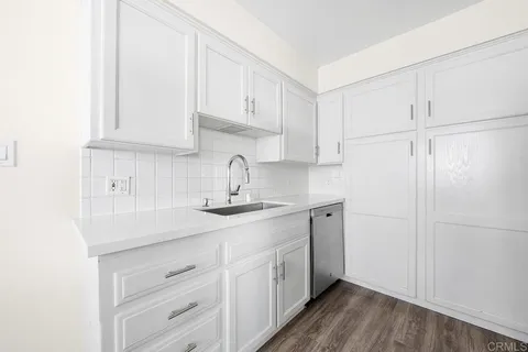 a kitchen with white cabinets and a sink