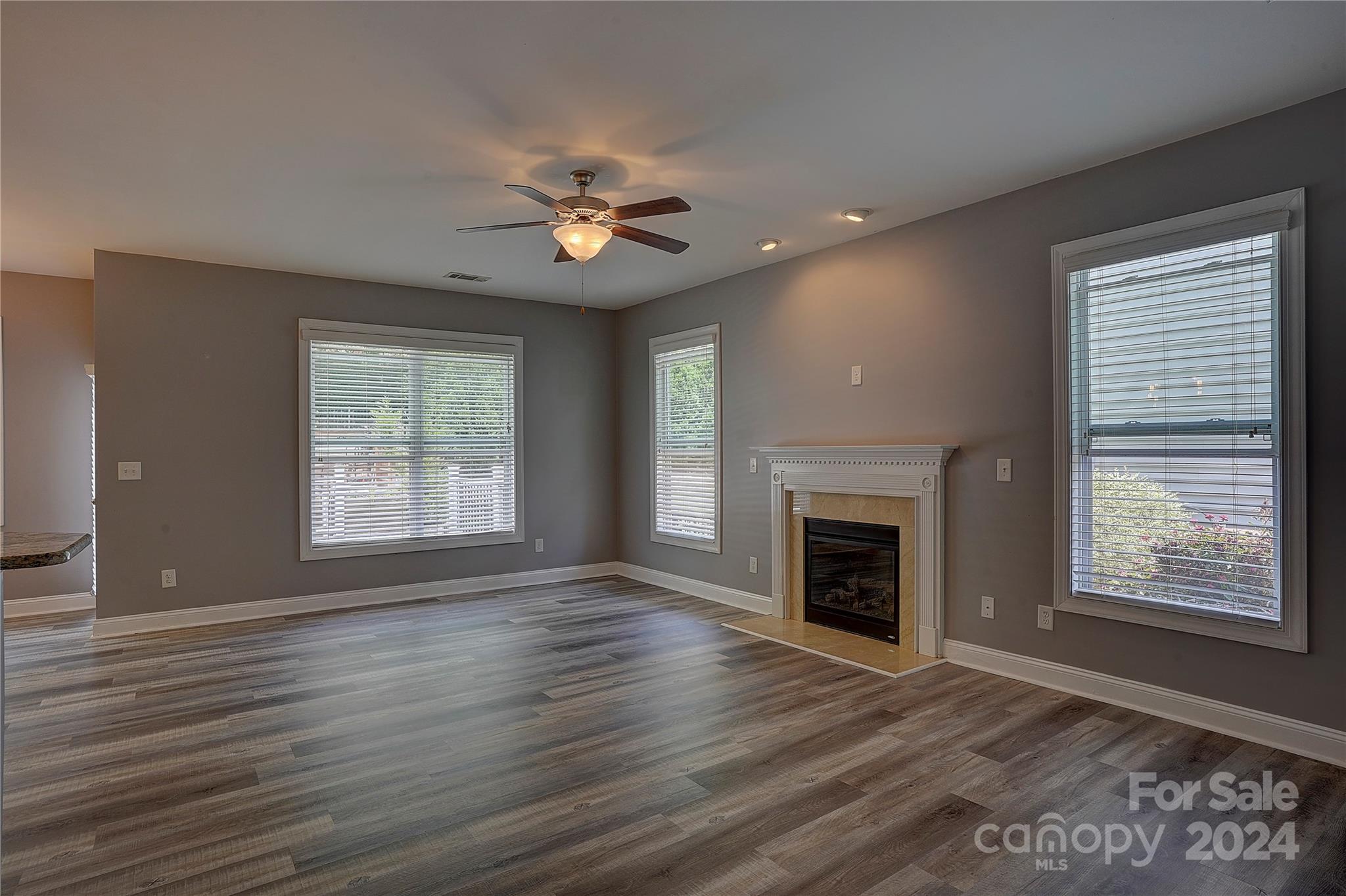 1024 Ridgehaven Road Waxhaw, NC 28173 - Photo 4 of 36 a view of an empty room with wooden floor fireplace and a window