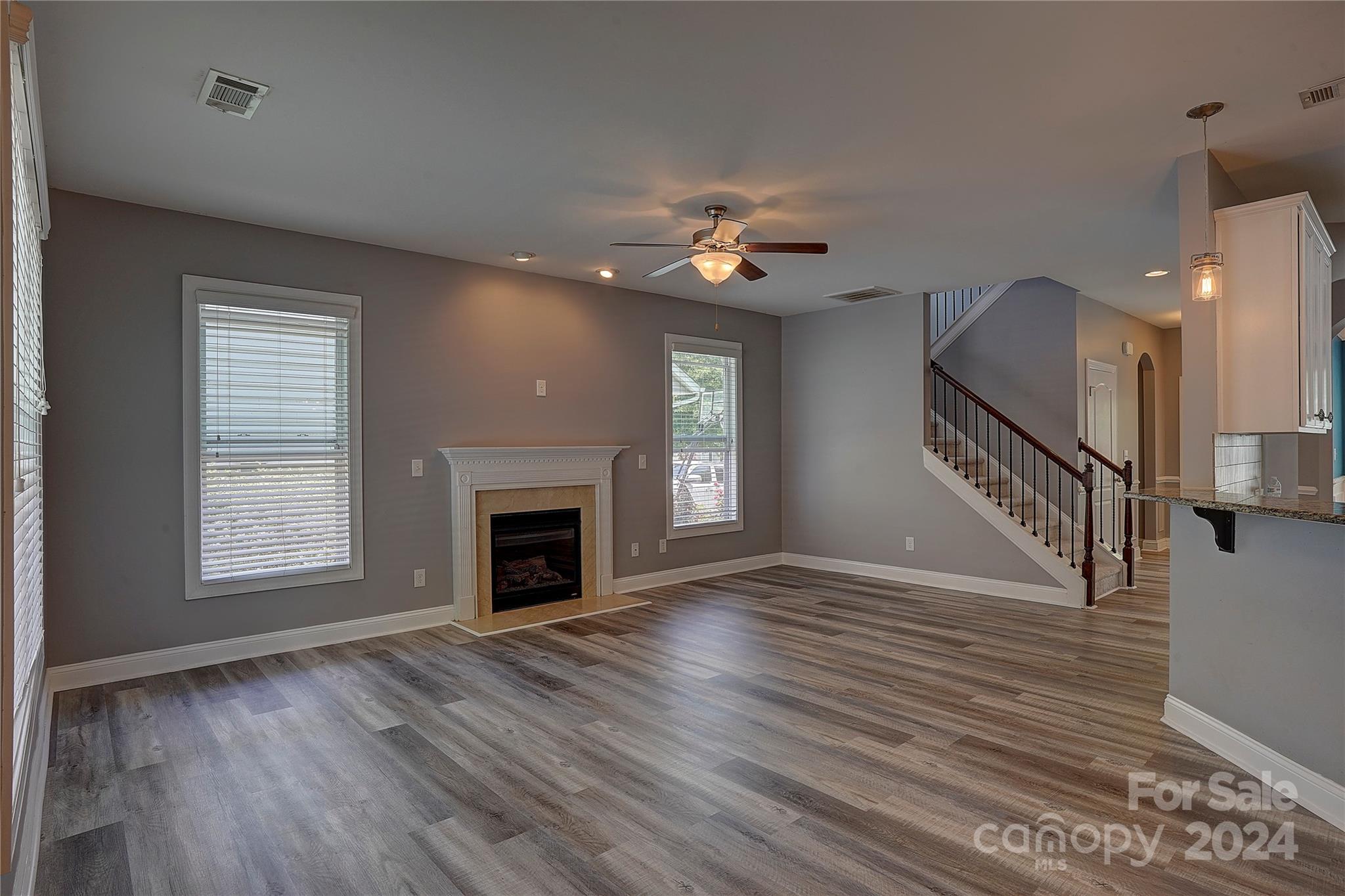 1024 Ridgehaven Road Waxhaw, NC 28173 - Photo 5 of 36 an empty room with wooden floor fireplace and windows