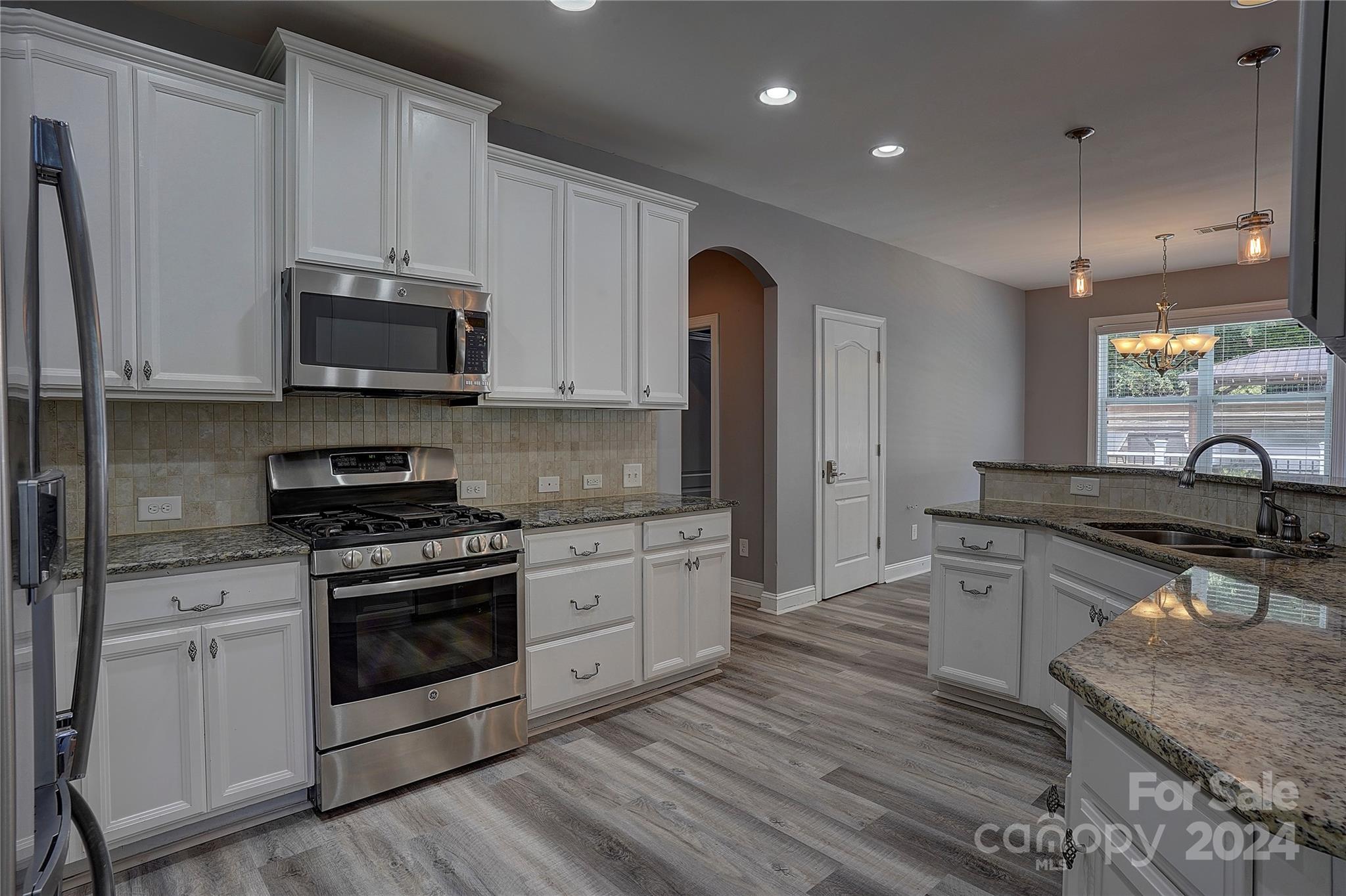 1024 Ridgehaven Road Waxhaw, NC 28173 - Photo 9 of 36 a kitchen with stainless steel appliances granite countertop a stove a sink and a microwave