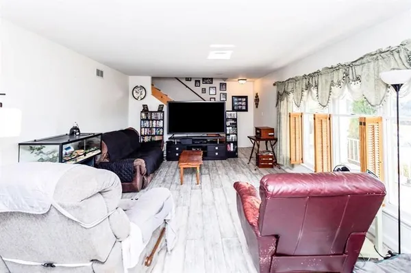 a living room with furniture a flat screen tv and a large window
