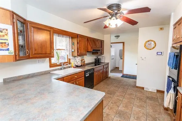 a kitchen with stainless steel appliances granite countertop a refrigerator a stove and a sink with cabinets