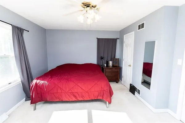 a bedroom with a bed and a large window