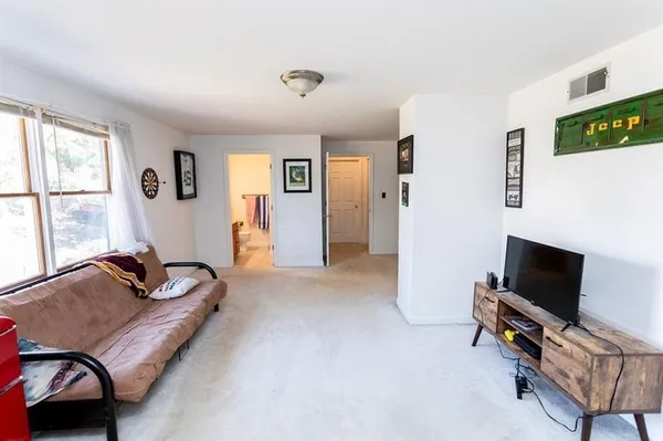 a living room with furniture and a gym machine