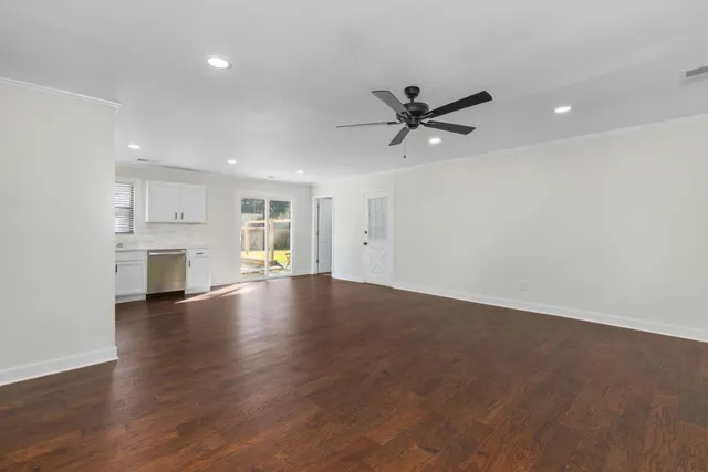a view of empty room with wooden floor and window