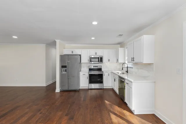 a kitchen with stainless steel appliances white cabinets and a sink