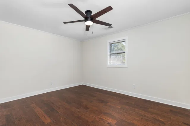 a view of a livingroom with wooden floor and a ceiling fan