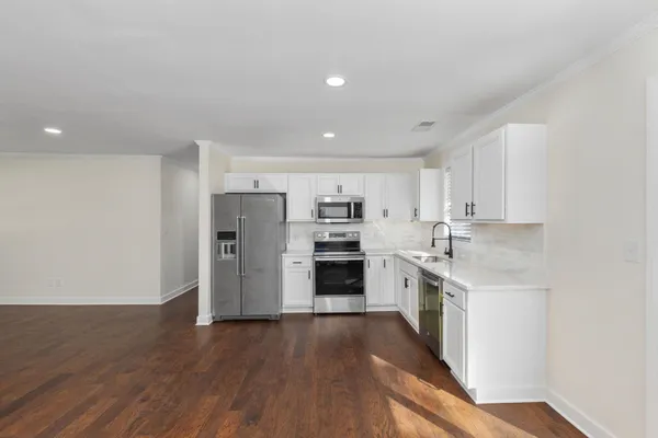 a kitchen with stainless steel appliances white cabinets and a sink