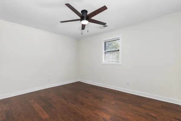 a view of a livingroom with wooden floor and a ceiling fan