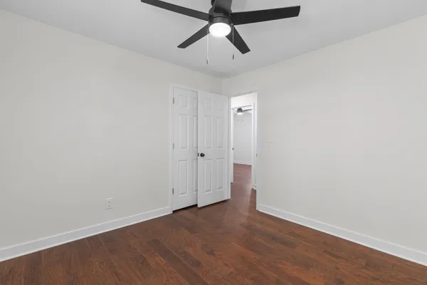a view of empty room with wooden floor