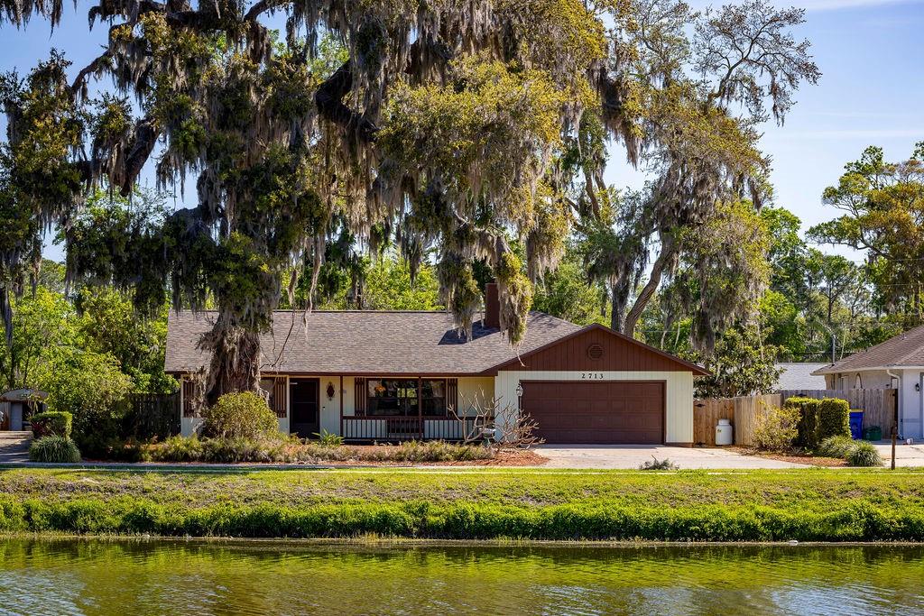 2713 Lime Tree Drive Edgewater, FL 32141 - Photo 1 of 1 a front view of a house with a garden and lake view