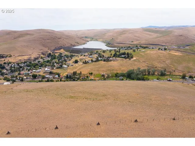 an aerial view of ocean and residential houses with outdoor space