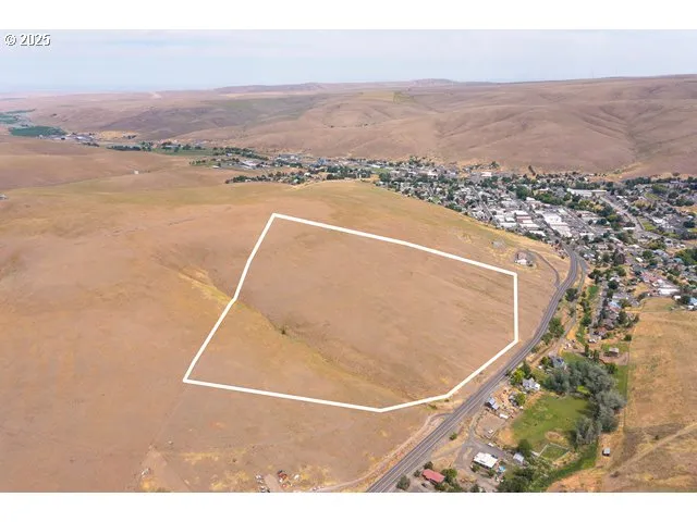 an aerial view of ocean and residential houses with outdoor space