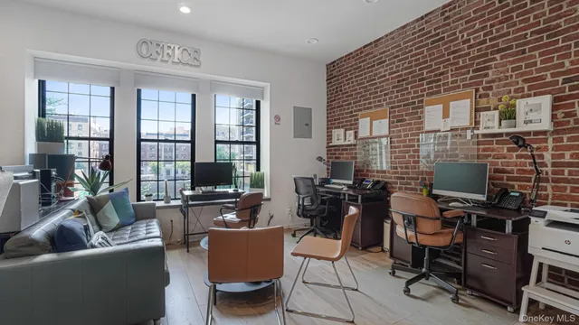 a work room with furniture and a floor to ceiling window