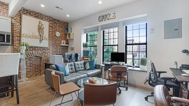 a view of a workspace with furniture and wooden floor