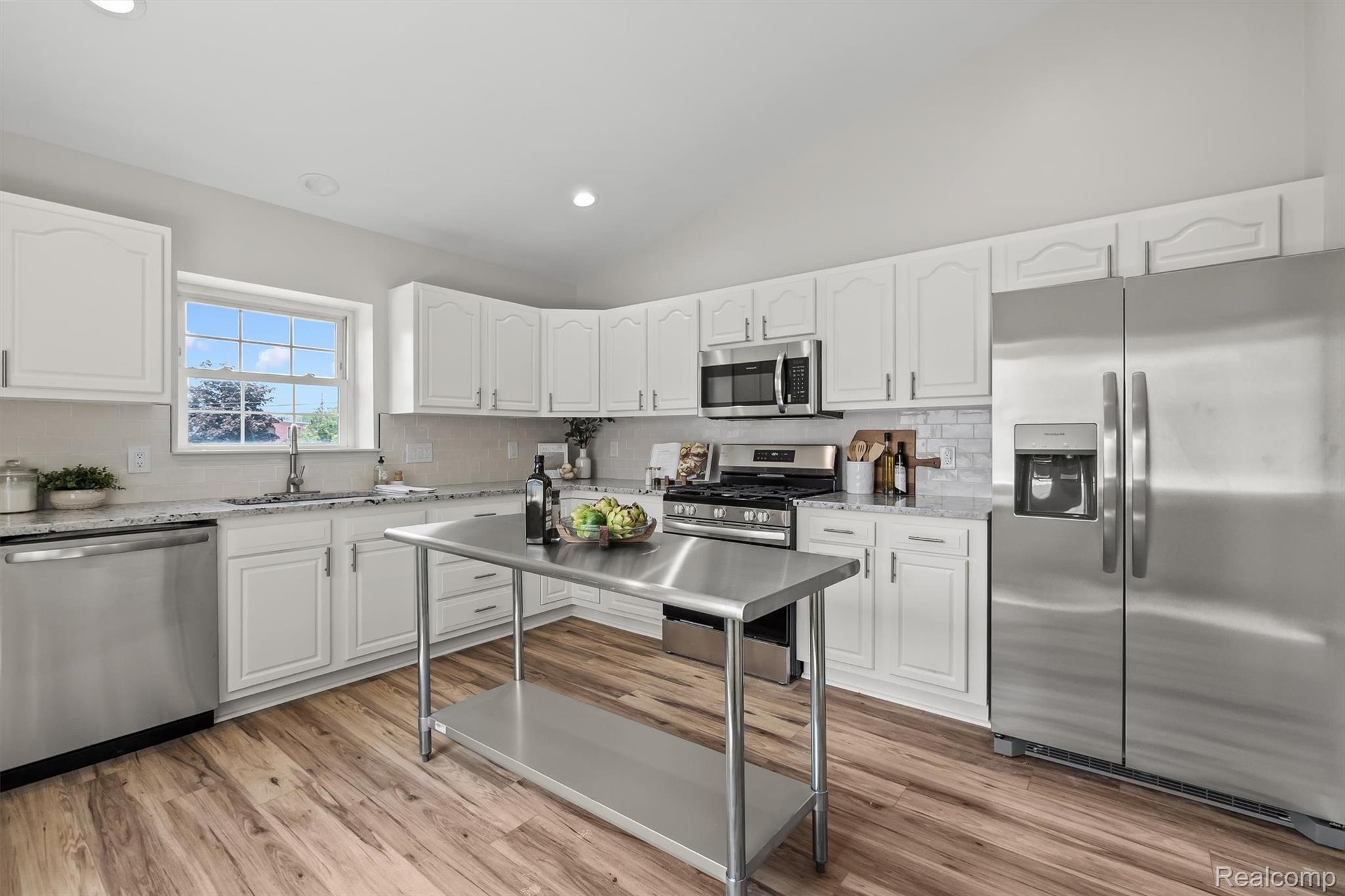 4427 Hannan Road Wayne, MI 48184 - Photo 8 of 33 White cabinetry with stainless steel hardware, granite countertops, wood-finish flooring, and recessed lighting