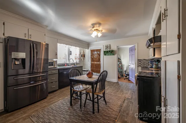 a kitchen with refrigerator and chairs