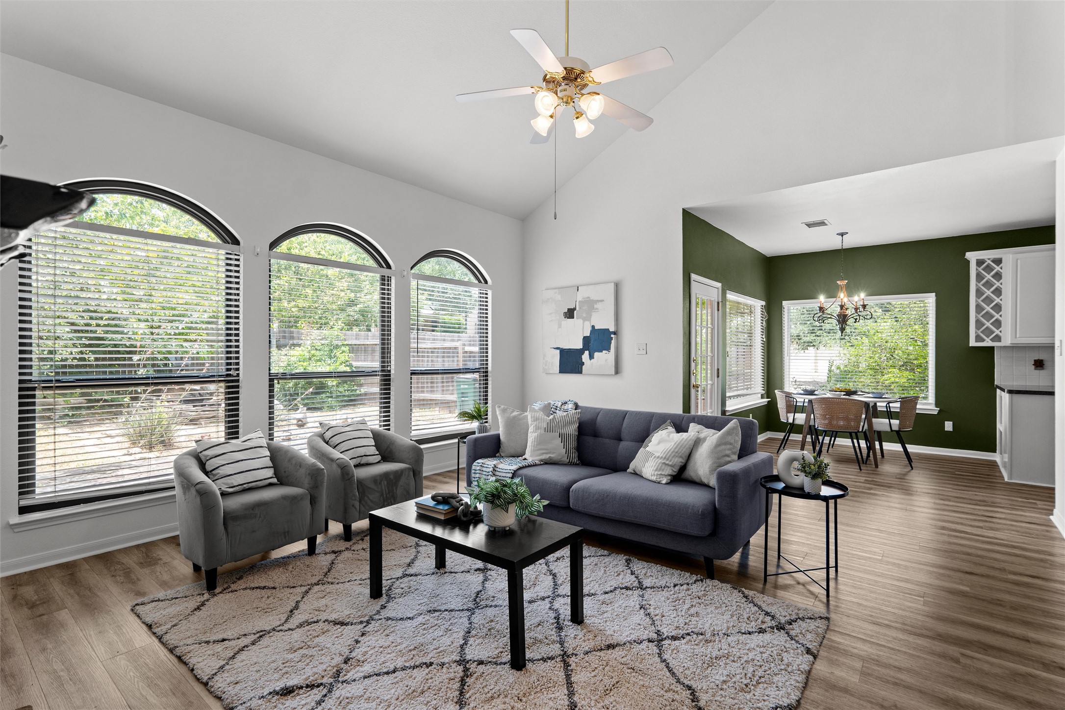 7000 Colberg Court Austin, TX 78749 - Photo 13 of 40 Natural light streams through arched windows, illuminating a living space with vaulted ceilings and elegant flooring.