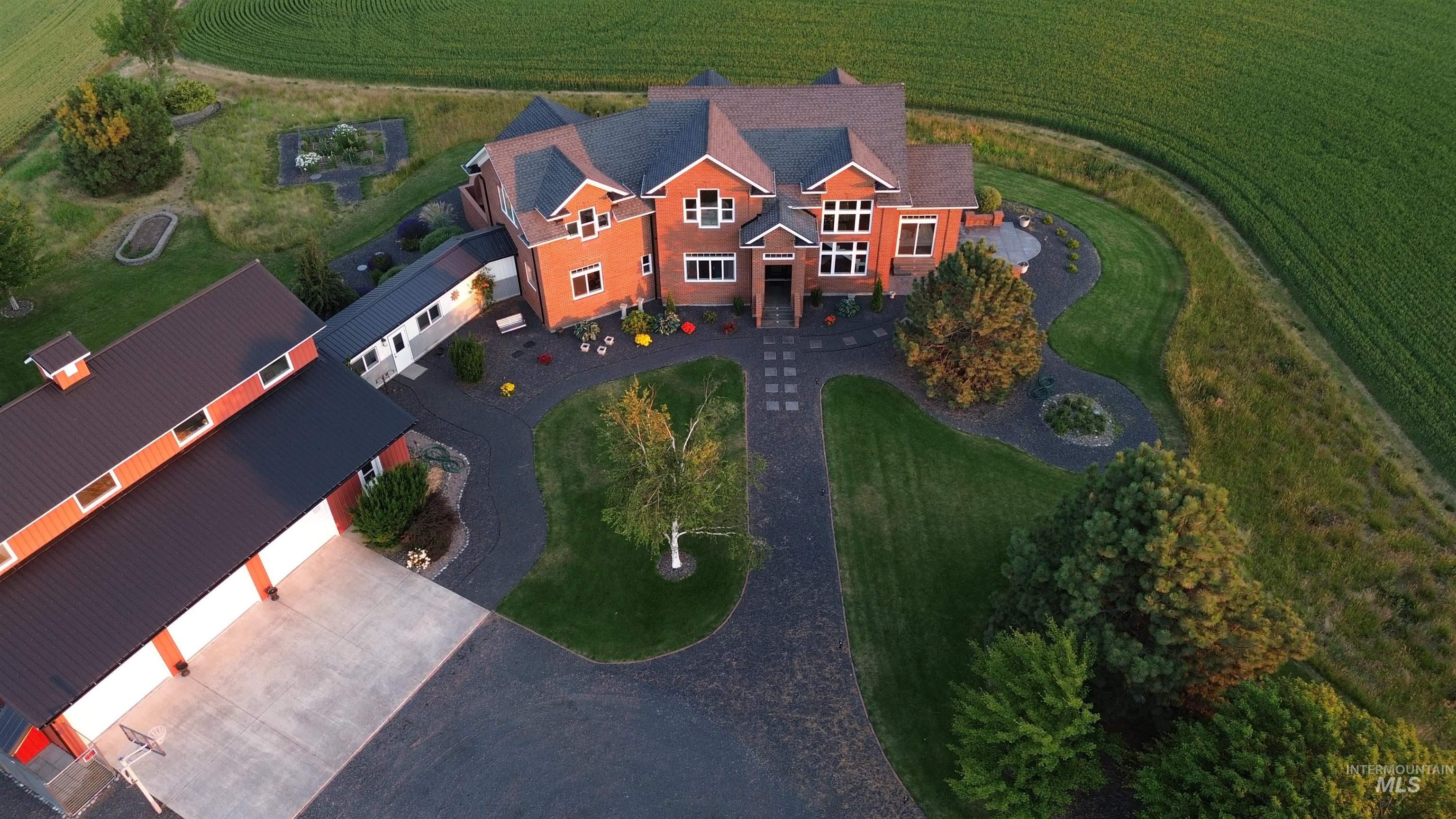 Brick exterior residence with a multi-gabled roofline and an attached outbuilding featuring multiple garage doors