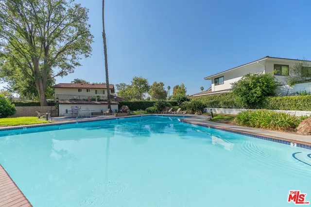 a view of a house with backyard swimming pool and sitting area