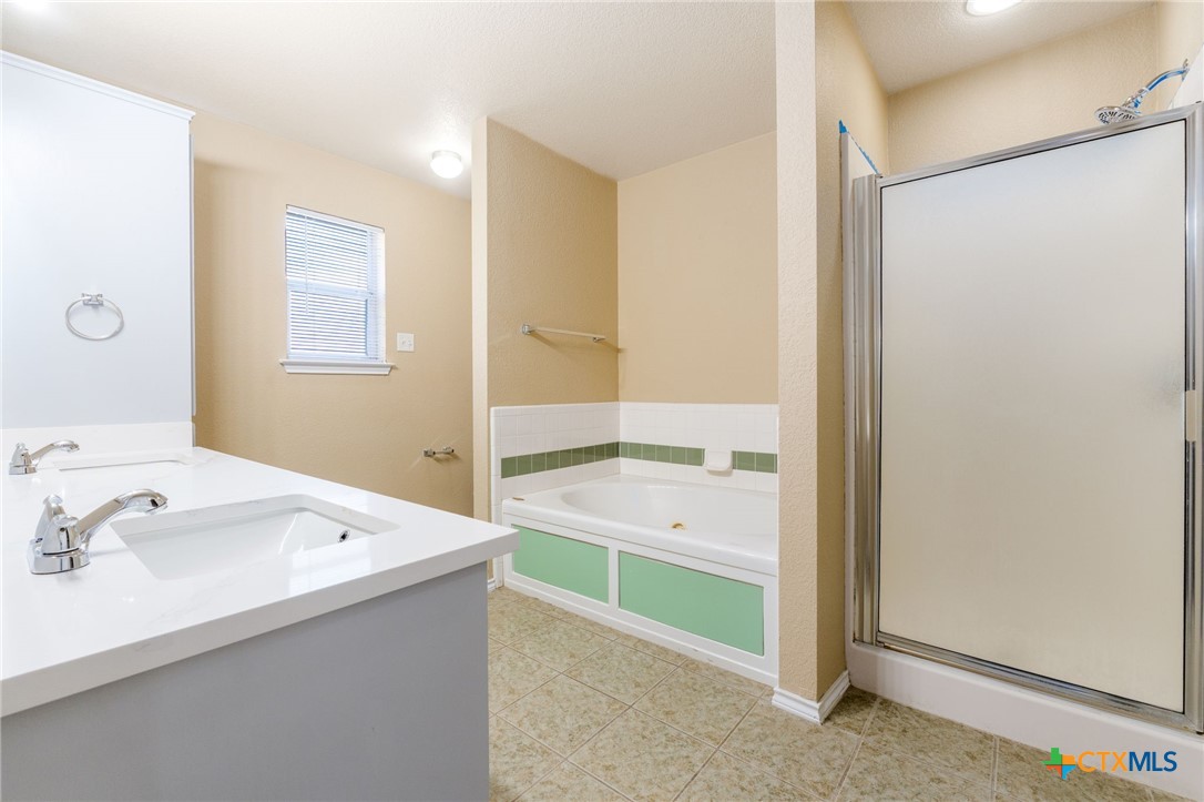 4701 Neta Drive Killeen, TX 76549 - Photo 15 of 28 a bathroom with a sink a mirror and a bathtub