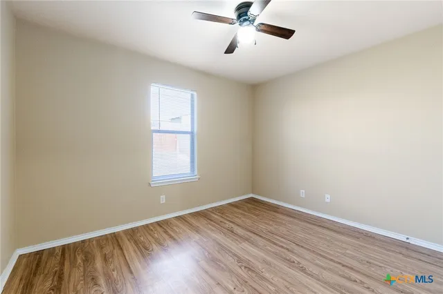 a view of a room with wooden floor and windows