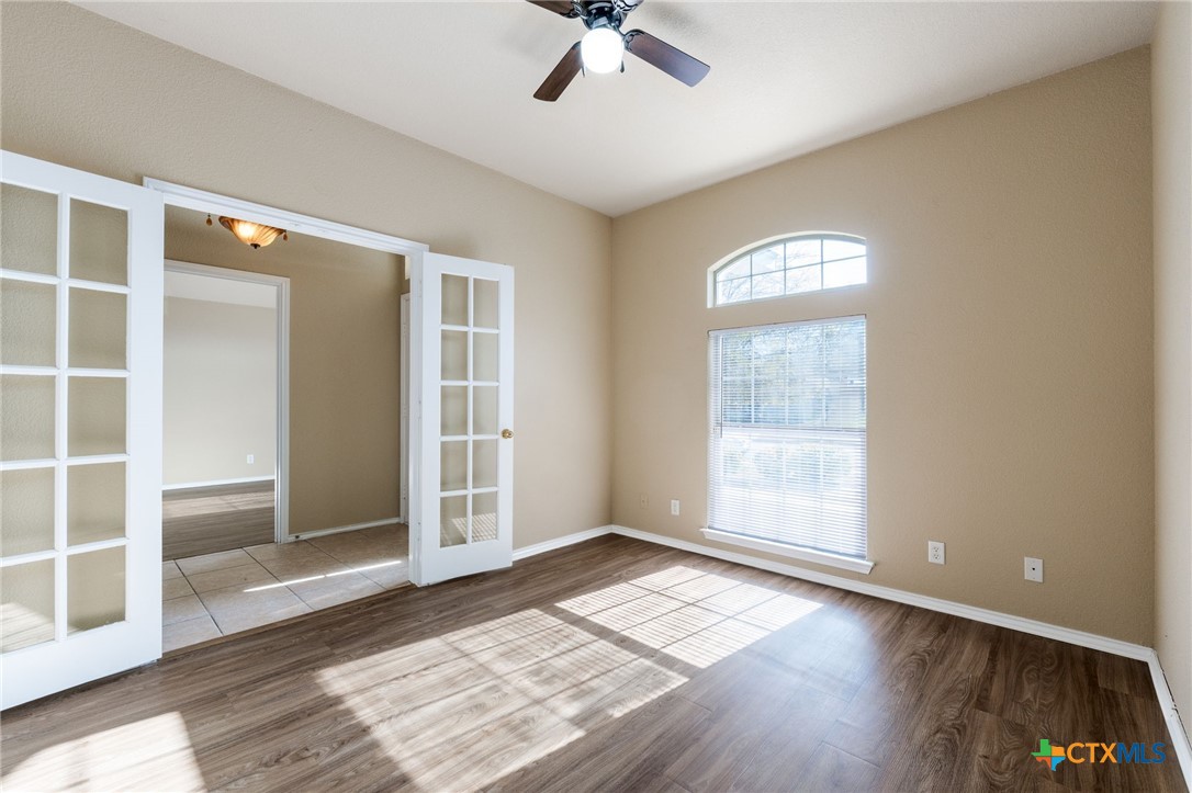 4701 Neta Drive Killeen, TX 76549 - Photo 7 of 28 an empty room with wooden floor cabinet and windows