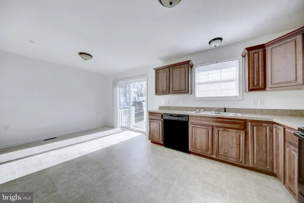 a large kitchen with granite countertop a sink dishwasher stove and cabinets
